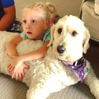 Una niña con parálisis cerebral se apoya en su perra …