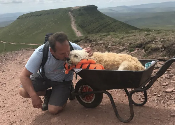 Un último paseo juntos: un hombre lleva a su can, enfermo terminal de cáncer, en carretilla a la montaña