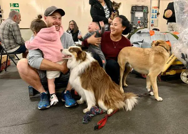 Sonrisas agradecidas y cansadas entre las familias -y sus perros- evacuadas de urgencia ante los incendios de Australia